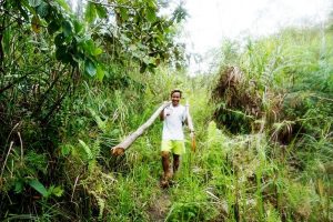 Dusur is carrying small logs in Kampung Sadir with Backyard Tour Malaysia